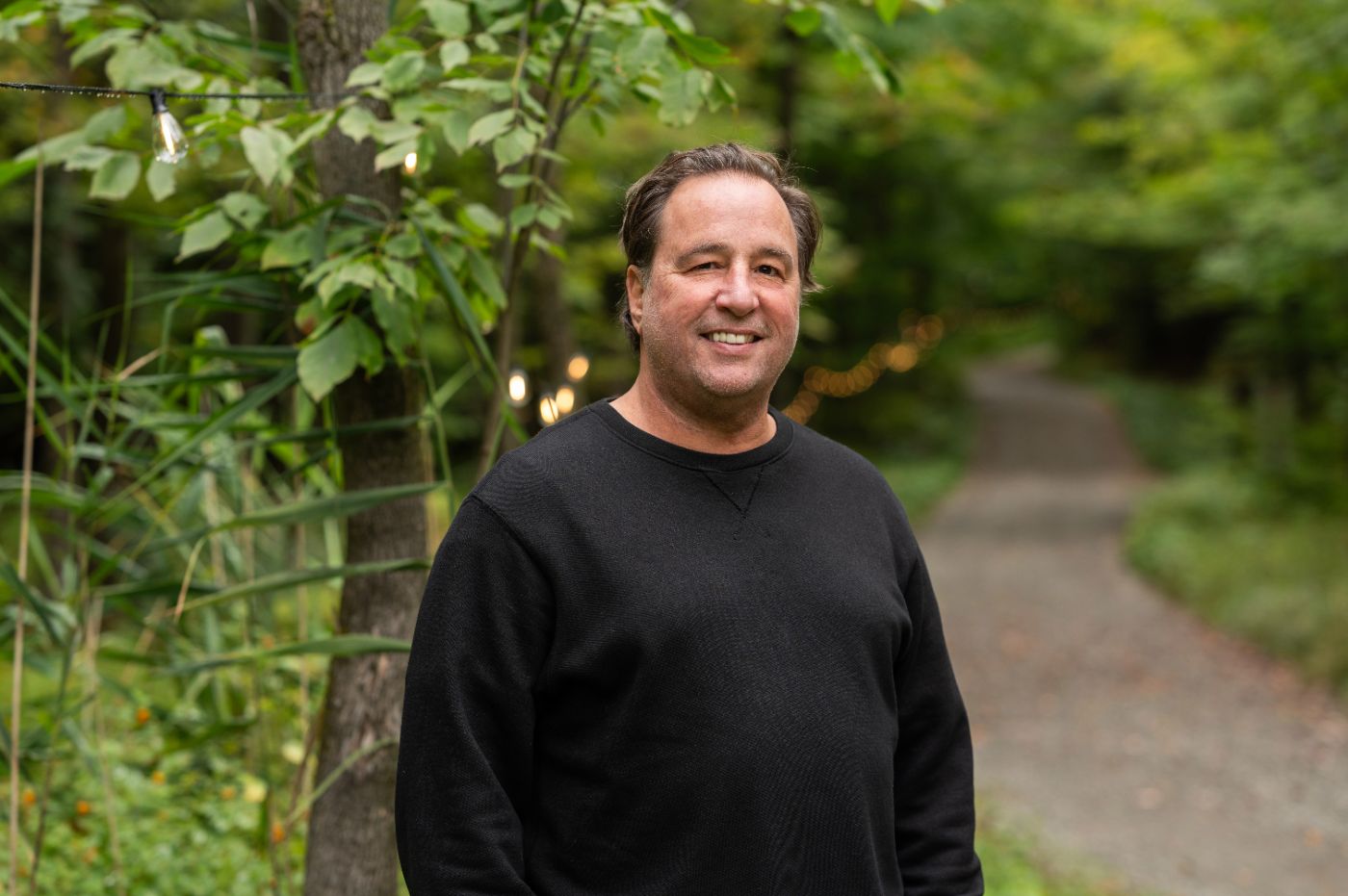 Christian Lefebvre, souriant, sur un sentier en forêt